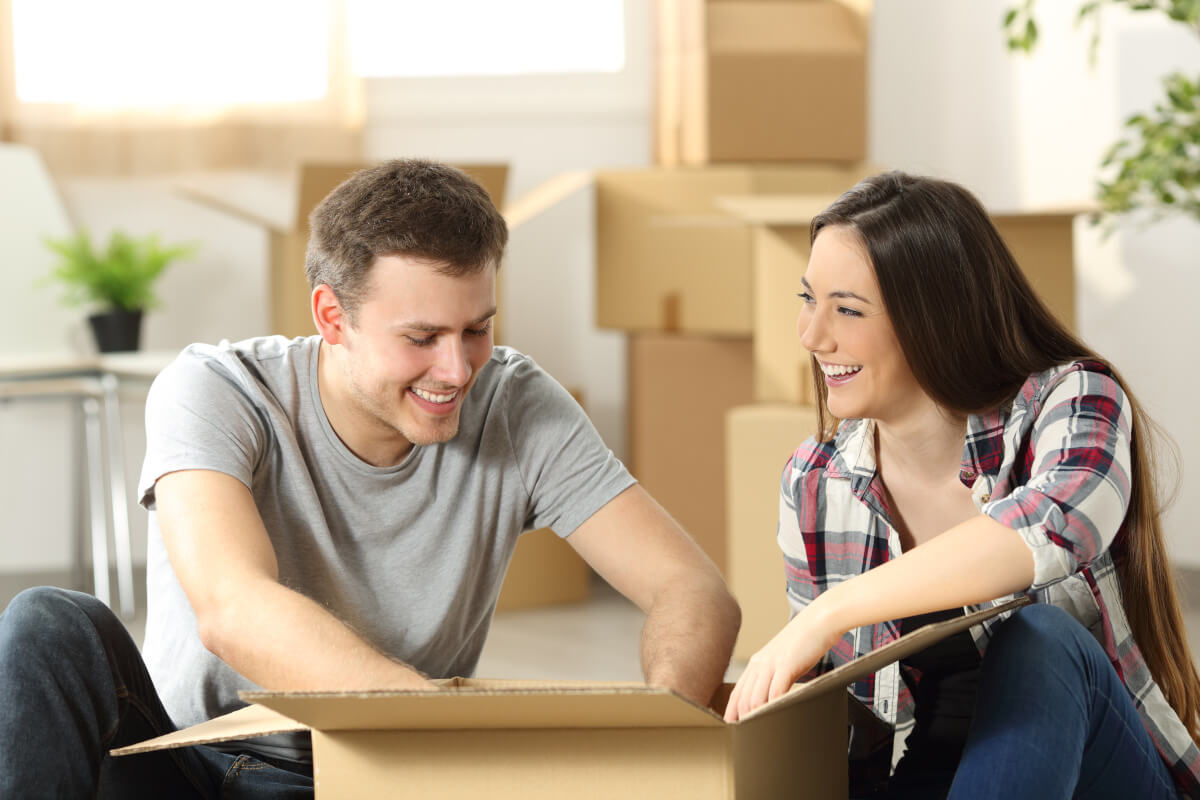 Roommates unpack moving boxes