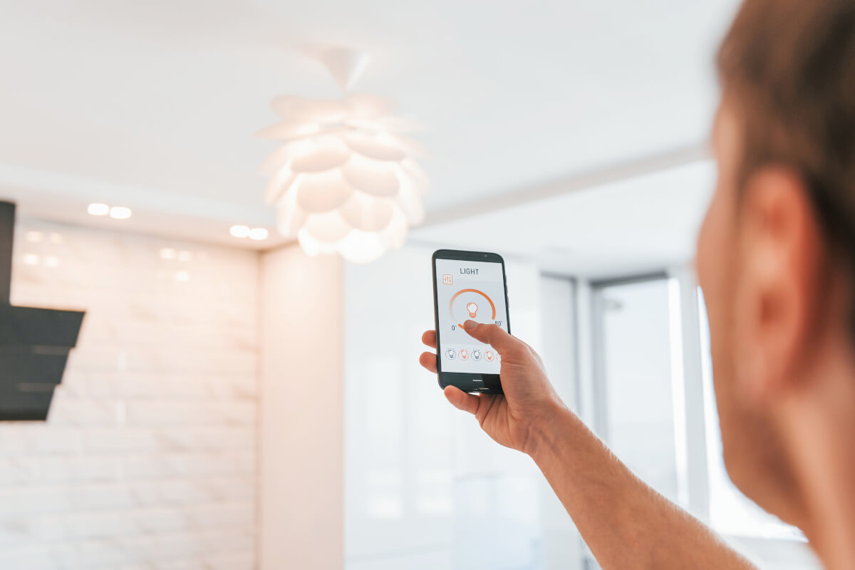 Renter adjusts smart lighting with his smartphone. 