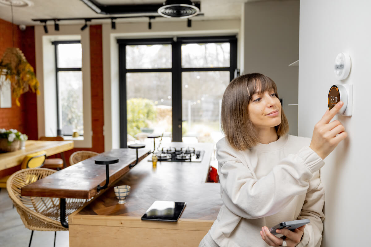 Renter adjusts smart thermostat. 